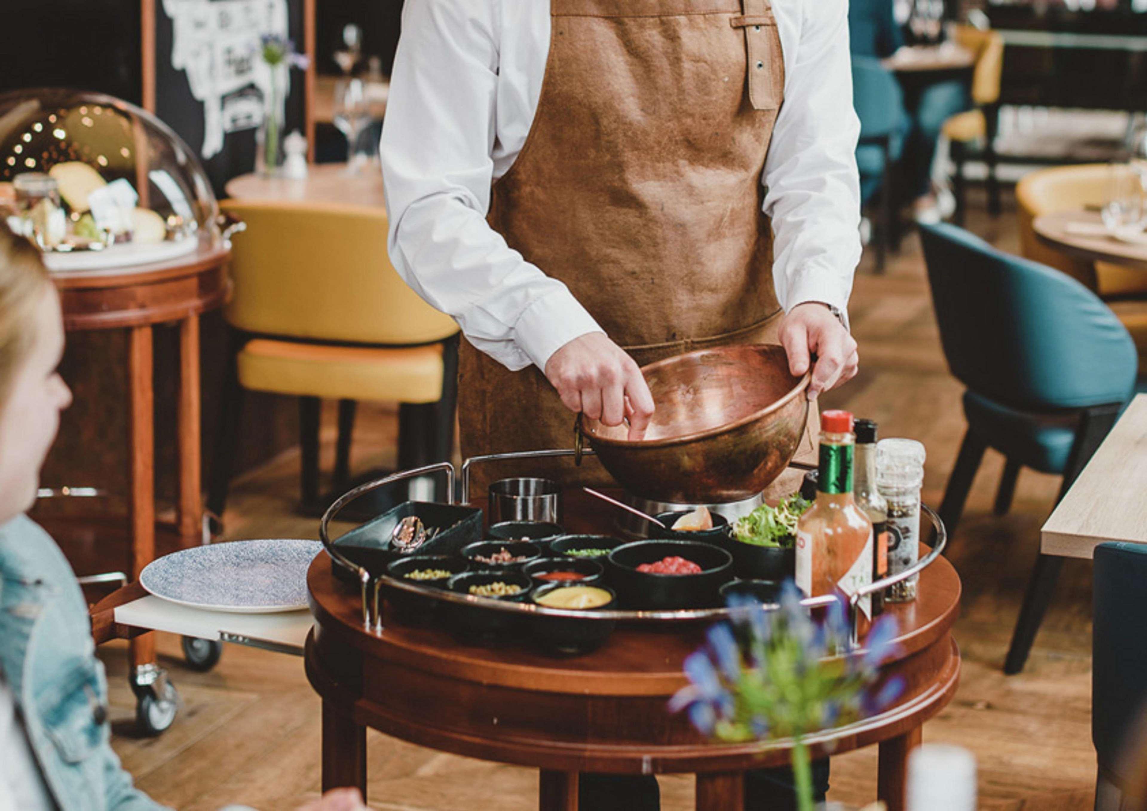 海牙希尔顿酒店 外观 照片 A server prepares a dish at a restaurant